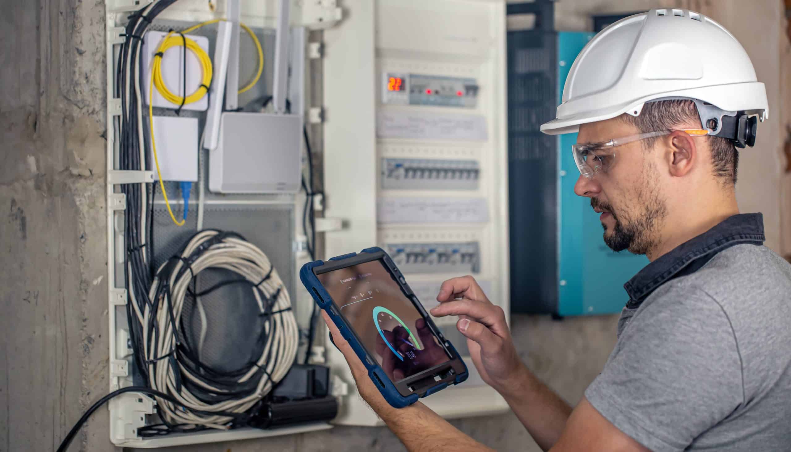 an electrical technician working in a switchboard with fuses