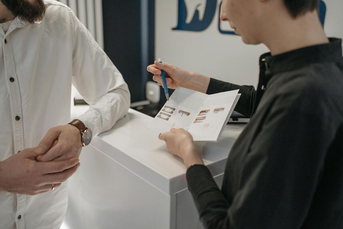 a woman holding a pen and looking at a booklet
