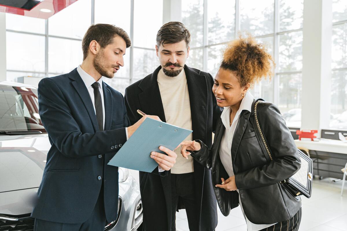 a group of people standing in front of a car