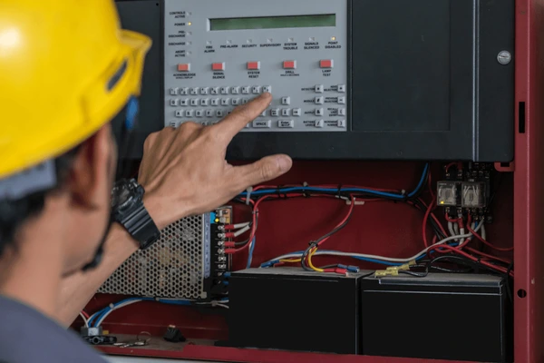 Technician performing security system maintenance and inspection