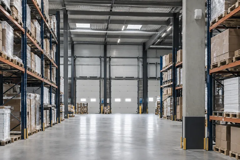 Orderly warehouse aisle with loading doors and a security detector